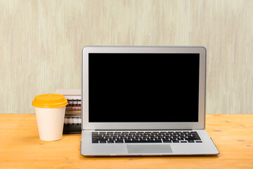 Fototapeta premium mocap Laptop with blank screen for product display and coffee on a wooden table.