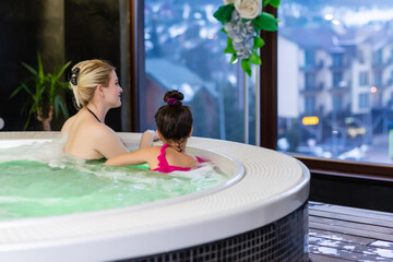 Woman with her daughter foot in hot tub jacuzzi