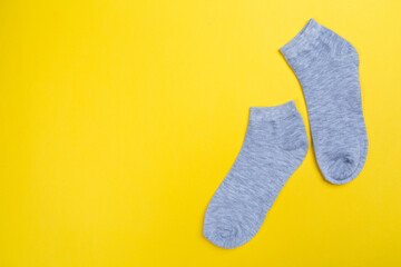 Top view of a pair of colored socks on a yellow background. Clothing in the form of socks.
