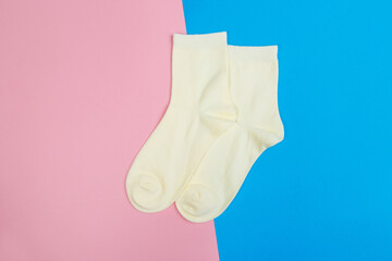 multicolored jersey socks on a pastel pink and blue background. view from above