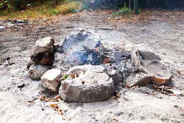 small smoking fire fenced with stones close up