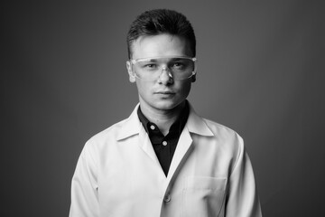 Portrait of young handsome man doctor as scientist