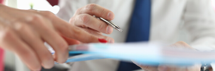 Man and woman are holding a folder with documents. The woman brought the chief a document for...