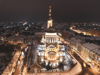 Holy Annunciation Cathedral illuminated in winter snowy evening lights. Aerial view Kharkiv city orthodox church in downtown, Ukraine. Front view from air