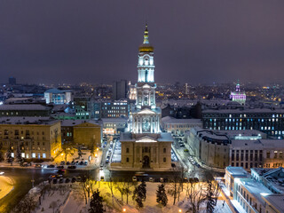 Dormition Cathedral illuminated in winter snowy evening lights. Aerial view Kharkiv city downtown, Ukraine. Front view from air