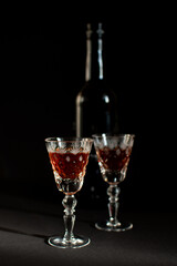 glasses and a bottle of alcohol on a black background