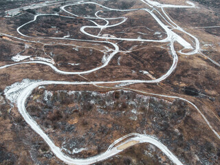 Dirt trail race track road aerial photo in winter with covered in snow lines. Outdoor sport racing terrain pattern