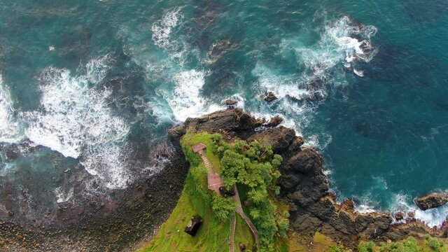 Top down aerial view on viewpoint on oceanfront cliff washed by turquoise ocean
