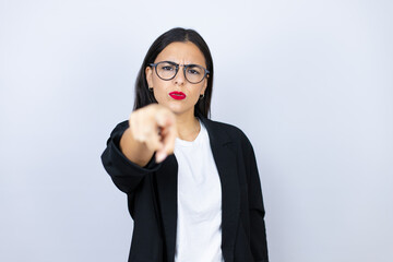 Beautiful business woman pointing with finger to the camera and to you, confident gesture looking serious