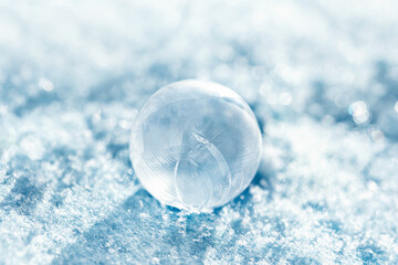 Obraz premium frozen bubble with bokeh background. Beautiful frosty patterns on frozen soap bubble. winter, frosty background. Macro photo