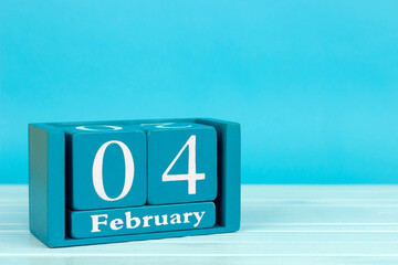 wooden calendar with the date of February 4 on a blue wooden background, World Cancer Day	