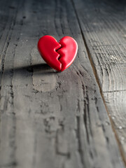 Red broken love heart on wooden background. Valentine's day concept.