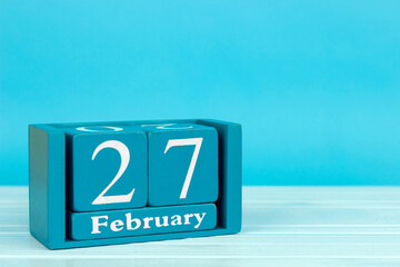 wooden calendar with the date of February 27 on a blue wooden background, World NGO Day; Anosmia Awareness Day; International Polar Bear Day	