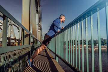 Young handsome man training hard. Man doing sports outside. Outdoors recreation, stretching and training fit body