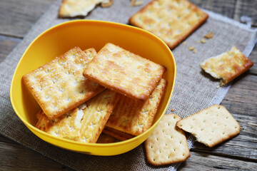 biscuit with sugar dessert in the yellow bowl put on sack and wood table, delicious cracker 