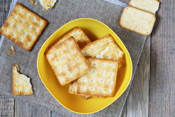 biscuit with sugar dessert in the yellow bowl put on sack and wood table, delicious cracker 