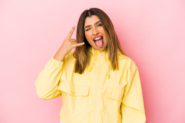 Young indian woman isolated on pink background showing rock gesture with fingers