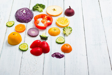 sliced fruit and vegetable circles on white wood table
