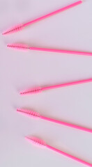 Pink makeup eyebrow brushes. Eyebrow and eyelash combs. Disposable pink brush for eyelashes and eyebrows. Vertical orientation.
