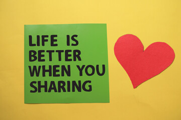 Life is better when you sharing, text words typography written on paper against yellow background, life and business motivational inspirational