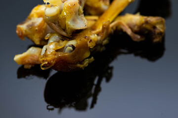 Deep fried chicken bones on shiny dark surface close up shot.