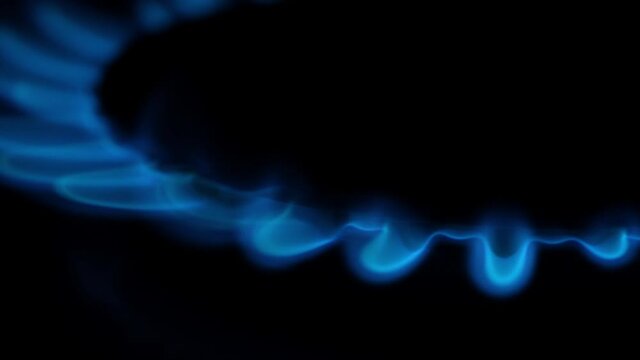 blue flames of burning gas close-up on a dark background
