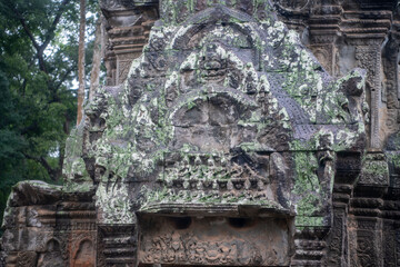 Fototapeta premium Та Prohm is the temple, it rains in the rainy season.The preserved symbiosis of stone and wood allows us to see Ta Prohm in this form.Bas-relief.(Cambodia, 04.10. 2019).