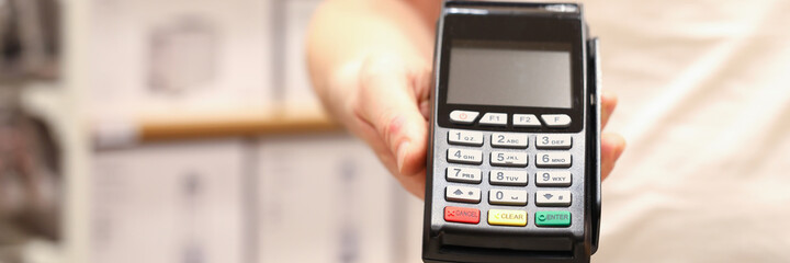 A guy in a white T-shirt is holding a wireless terminal in the background of a warehouse. Payment for goods and services via the Internet