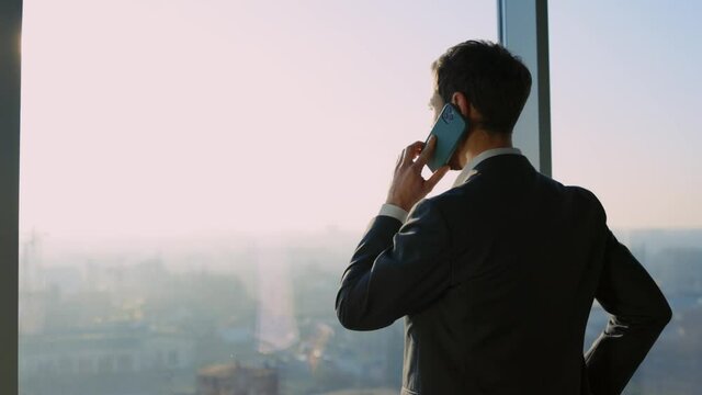 Corporate leader young businessman making phone call to business partner solving investment issues working at office cabinet. Business person. Conversation.