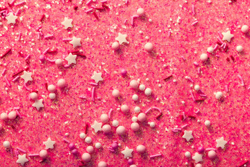 Abstract festive pink background with glitter, stars, confetti close-up
