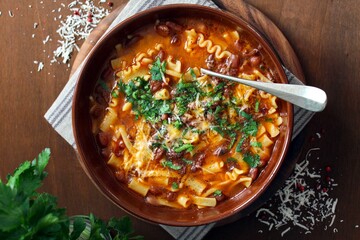 Pasta and beans soup with parmesan cheese. Top view with copy space. Vegetarian and vegan food.