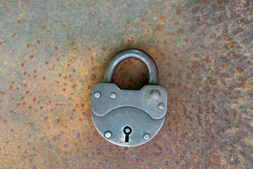Closed old rusty lock lying on the rusty iron surface. Copy space. Copy space.looking for problem...