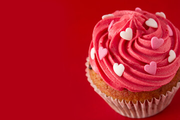 Cupcakes decorated with sugar hearts for Valentine's Day on red background.Copy space