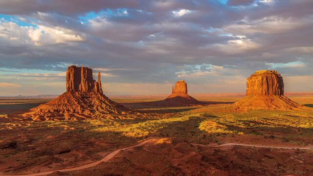 Beautiful orange and pink sunset timelapse with unique geological rock formations and clouds flowing in Monument Valley, Arizona United States