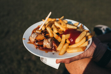 french fries with ketchup and a sausage with curry sauce