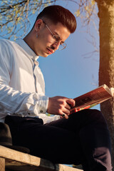 young boy reading a book in the sunlight