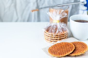 Traditional local authentic Dutch Netherlands sweet fresh homemade tasty stack brown golden waffle melt salted caramel honey syrup for dessert in cafe with hot warm coffee milk tea call Stroopwafel
