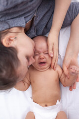 Mom soothes a crying newborn, top view