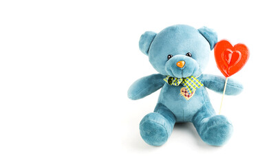 Turquoise soft teddy bear with red lollipop heart on a stick on a white background. Love, a gift to...