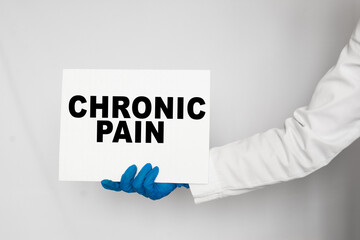 The doctor's blue - gloved hands show the word CHRONIC PAIN - . a gloved hand on a white background. Medical concept. the medicine