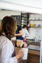 Asian coffee shop owner manager reopen the store after virus pandemic with blurred image of employee