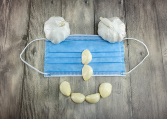 Fototapeta premium Human face of garlic and a hygienic mask