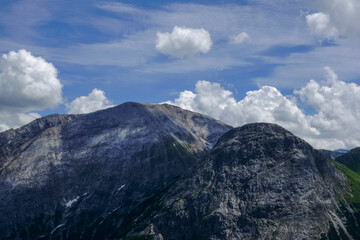 Obraz premium high steep mountains with white clouds on the blue sky