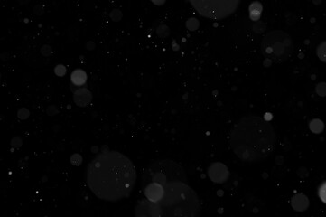 Bokeh of white snow on a black background. Snowfall - design element.