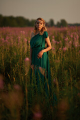 Young beautiful girl with a bouquet of flowers in her hands at sunset.