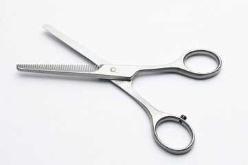 Pair of hair thinning scissors on white background