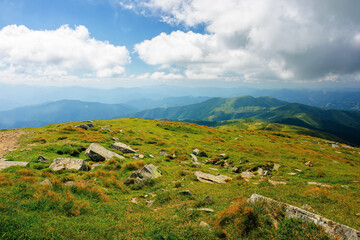 carpathian summer mountain landscape. beautiful countryside with rocks on the grassy hill. view in to the distant valley. clouds on the blue sky. wonderful travel destination