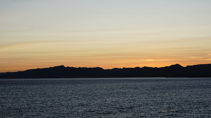 sea side mountain silhouette at sunset