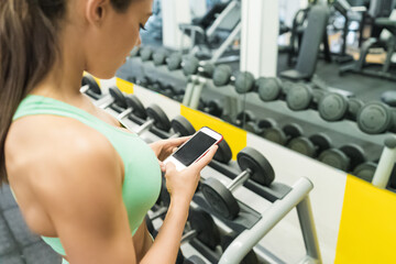Fototapeta premium Sportswoman using mobile in gym