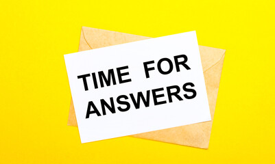 On a yellow background, an envelope and a card with the text TIME FOR ANSWERS. View from above